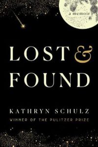 A book cover featuring a black night sky. There are gold stars around the edges of the cover, with a full moon in the top right hand corner and a shooting star to the left of it. The moon has 'a memoir' written on it. The book title 'Lost and Found' is in the center of the book. The author's name 'Kathryn Schulz' is beneath the title. 'Winner of the Pulitzer Prize' is written under the author's name. The text is in white and gold.