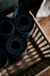 Black yoga mats rolled up in a basket